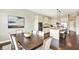 Open-concept dining area with a modern table set, seamlessly connected to the kitchen and featuring hardwood floors at 2715 Benmore Ct, Zionsville, IN 46077