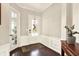 Elegant foyer featuring hardwood floors, wainscoting, a decorative rug, and a glass-paned front door at 2715 Benmore Ct, Zionsville, IN 46077