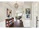 Spacious foyer with hardwood floors, elegant lighting, and archways leading to the living areas at 2715 Benmore Ct, Zionsville, IN 46077