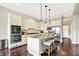 Bright kitchen with white cabinets, granite countertops, stainless steel appliances, and a kitchen island with seating at 2715 Benmore Ct, Zionsville, IN 46077