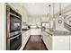 Modern kitchen with white cabinets, granite countertops, stainless steel appliances, and an island with seating at 2715 Benmore Ct, Zionsville, IN 46077
