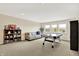 Spacious living room featuring neutral carpet, ample natural light, and an air hockey table for entertainment at 2715 Benmore Ct, Zionsville, IN 46077