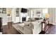 Comfortable living room with a fireplace, built-ins, large windows, and access to other living spaces at 2715 Benmore Ct, Zionsville, IN 46077