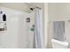 Bright bathroom shower featuring a neutral curtain and built-in shelving for storage at 2715 Benmore Ct, Zionsville, IN 46077