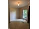 Bedroom with neutral colored walls and carpet, with light fixture and window at 3042 S Conservation Club Rd, Morgantown, IN 46160
