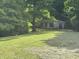 Single-story home nestled amongst a lush backdrop of mature trees creating privacy and shade at 3042 S Conservation Club Rd, Morgantown, IN 46160