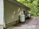 View of the home's siding with a large propane tank, side door, and access stairs at 3042 S Conservation Club Rd, Morgantown, IN 46160
