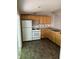 Kitchen with wood cabinets, white appliances, and dark vinyl flooring at 3042 S Conservation Club Rd, Morgantown, IN 46160