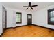A bright bedroom with hardwood floors, a ceiling fan, and updated windows with wood trim at 3246 N New Jersey St, Indianapolis, IN 46205