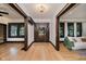Inviting foyer with wood floors, dark trim, decorative shelving, and a view into the main living area at 3246 N New Jersey St, Indianapolis, IN 46205