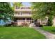 Charming two-story home with a screened-in porch, lush lawn, and mature trees, providing curb appeal at 3246 N New Jersey St, Indianapolis, IN 46205