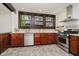 Well-lit kitchen showcases stainless appliances, granite counters, dark cabinetry, and tile flooring at 3246 N New Jersey St, Indianapolis, IN 46205