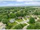 A picturesque aerial view of a neighborhood showcasing lush greenery and well-maintained homes under a blue sky at 3439 Eden Park Dr, Carmel, IN 46033