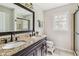 Bathroom featuring double sinks, granite countertop, dark cabinetry, and shower at 3439 Eden Park Dr, Carmel, IN 46033