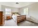 Cozy bedroom with wood frame bed, two windows, neutral paint, and soft carpet at 3439 Eden Park Dr, Carmel, IN 46033
