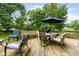 Spacious deck features outdoor seating, including chairs, a bench, and a dining table with an umbrella at 3439 Eden Park Dr, Carmel, IN 46033