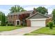 Charming brick home featuring a two-car garage and a well-maintained front yard with mature trees at 3439 Eden Park Dr, Carmel, IN 46033
