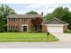Charming brick home featuring a two-car garage and a well-maintained front yard with mature trees at 3439 Eden Park Dr, Carmel, IN 46033
