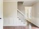 Hallway featuring hardwood floors, paneled walls, and bright staircase at 3439 Eden Park Dr, Carmel, IN 46033