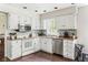 Bright kitchen features white cabinets, stainless steel appliances, and hardwood floors at 3439 Eden Park Dr, Carmel, IN 46033