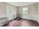 Living room with hardwood floors, wainscoting, two windows, and neutral paint at 3439 Eden Park Dr, Carmel, IN 46033