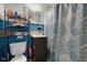 Blue-tiled bathroom featuring a shower with a patterned curtain at 3509 N Wittfield St, Indianapolis, IN 46235