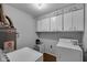 Practical laundry room equipped with a washer, dryer, and ample storage cabinets for convenience at 3509 N Wittfield St, Indianapolis, IN 46235