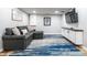 Finished basement with a gray sofa, TV, and storage cabinets, plus a blue and gray area rug at 3715 Rolling Springs Dr, Carmel, IN 46033
