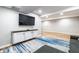 Cozy basement with a large TV, white storage cabinets, and a stylish gray and blue area rug at 3715 Rolling Springs Dr, Carmel, IN 46033