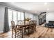 Bright dining area with a wood table, chairs, large window, and staircase at 3715 Rolling Springs Dr, Carmel, IN 46033