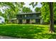 Charming two-story home featuring a stone facade, lush green lawn, and mature trees at 3715 Rolling Springs Dr, Carmel, IN 46033