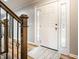 Bright foyer with a white front door, side windows, wood floors, and staircase at 3715 Rolling Springs Dr, Carmel, IN 46033