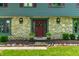 Charming front entrance featuring a stone facade, red door, and manicured landscaping at 3715 Rolling Springs Dr, Carmel, IN 46033