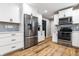 Modern kitchen with stainless steel appliances, white cabinets, subway tile backsplash, and wood-look floors at 3715 Rolling Springs Dr, Carmel, IN 46033