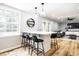 Open-concept kitchen bar with pendant lights overlooks the spacious living room with access to the backyard at 3715 Rolling Springs Dr, Carmel, IN 46033