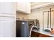 Convenient laundry room equipped with a modern washer/dryer, storage cabinets, and laminate wood flooring at 3715 Rolling Springs Dr, Carmel, IN 46033