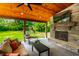 Covered outdoor living area with a fireplace, TV, comfortable seating, and a view of the backyard at 3715 Rolling Springs Dr, Carmel, IN 46033