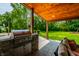 Outdoor kitchen area with built-in grill, stone accents, and a view of the lush backyard at 3715 Rolling Springs Dr, Carmel, IN 46033