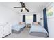 Charming bedroom showcases two twin beds, ceiling fan, and a window providing natural light at 3740 Cheviot Pl, Indianapolis, IN 46205