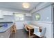 Bright dining area adjacent to kitchen featuring modern furniture and wainscoting details at 3740 Cheviot Pl, Indianapolis, IN 46205