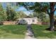 Well-maintained front yard with mature trees, green grass, and a pathway to the front door at 3740 Cheviot Pl, Indianapolis, IN 46205