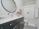 Well-lit bathroom features vanity with black cabinets and white countertop and decorative round mirror at 3821 Shady Lake Dr, Westfield, IN 46074