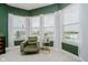 Bright sitting area with large windows overlooking water feature, green chair and gold accent table at 3821 Shady Lake Dr, Westfield, IN 46074