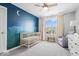 Charming Bedroom with playful wall mural, crib, comfortable chair, and plenty of natural light at 4253 Ironclad Dr, Bargersville, IN 46106