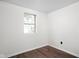 Minimalist bedroom features neutral walls, hardwood floors, and a single window at 4502 Evanston Ave, Indianapolis, IN 46205