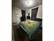 Bedroom featuring green bedding, dark curtains, and a mounted television at 4744 E 33Rd St, Indianapolis, IN 46218