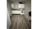 The kitchen features laminate floors, white cabinets and appliances, and natural light at 4744 E 33Rd St, Indianapolis, IN 46218