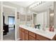Bathroom with a double vanity and an oversized mirror reflecting the bedroom at 5011 Amber Creek Pl # 310, Indianapolis, IN 46237
