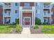 Attractive condo complex featuring brick accents, white pillars, green grass, blue siding, and a central entryway at 5011 Amber Creek Pl # 310, Indianapolis, IN 46237