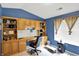 Blue home office features built in shelving, large window, and a desk for working at home at 5011 Amber Creek Pl # 310, Indianapolis, IN 46237